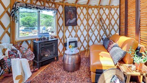 Un interior acogedor con un sofá, una chimenea y un ventanal grande.