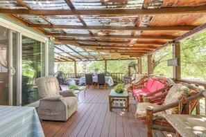 A covered deck with wooden furniture, a table, and chairs. - Auburn Cottage w/ Patios & Garden - 3 Mi to Town! (Auburn)