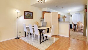 Uma sala de jantar com uma mesa, cadeiras, um globo e um quadro na parede.