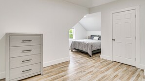 Un dormitorio con cama, cómoda y puerta.