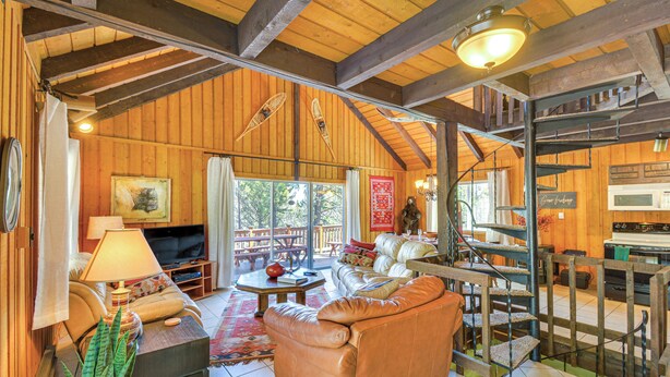 A spacious living area with a leather sofa, a coffee table, and a TV. There is a staircase leading to an upper level. - 'mccall Creekside Cabin' Secluded Buena Vista Gem! (Buena Vista)