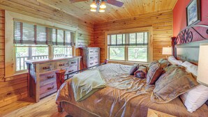 A wooden cabin bedroom with a bed, dresser, and a ceiling fan. - 4 Mi to Grandfather Mtn! Family-friendly Cabin (Newland)