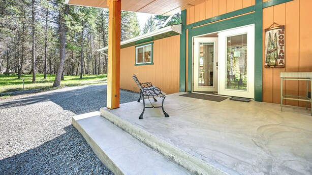 A wooden building with a covered porch, a bench, and a door with a glass panel. - Peaceful Eureka Getaway - 1 Mi to Glen Lake! (Eureka)
