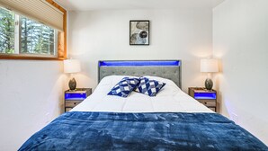 A bedroom with a bed, two nightstands, a window, and a wall-mounted artwork. - Peaceful Eureka Getaway - 1 Mi to Glen Lake! (Eureka)