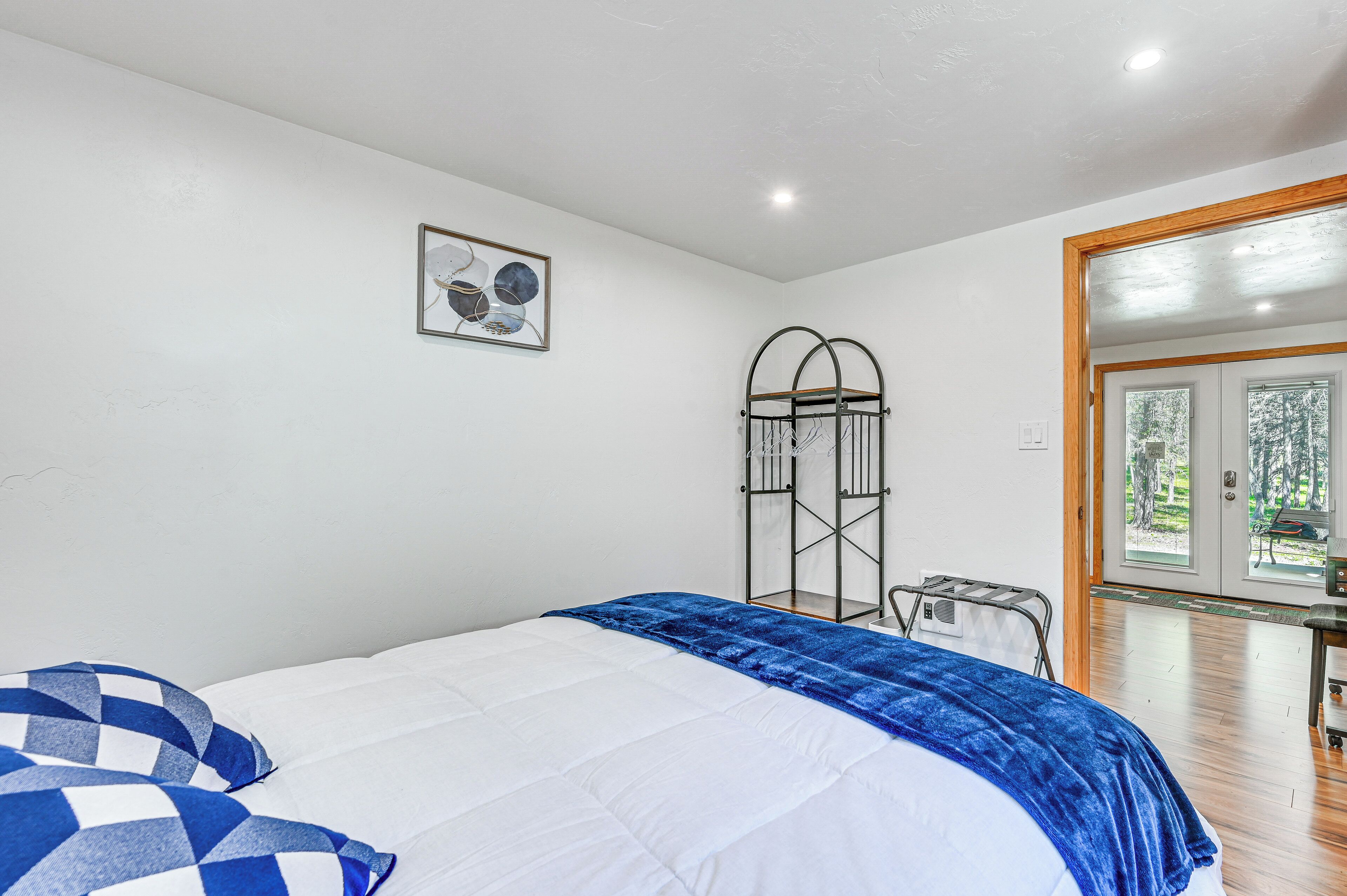 A bedroom with a bed, a window, and a door leading outside.