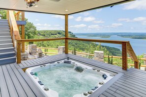 A hot tub on a wooden deck with a view of a lake and forest. - Luxe Home w/ Panoramic Greers Ferry Lake Views (Quitman)