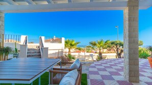 An outdoor patio with a checkered floor, a wooden table, and wicker chairs. - Villa Sierra Sea Views Quesada with private swimming pool (Ciudad Quesada)