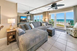 A spacious bedroom with a large bed, a seating area, and a balcony with a view of the ocean. - 🌴Gulf Front-Pools-Gazebo-Grills-Dunes of Panama 205D🌴 (Panama City Beach)