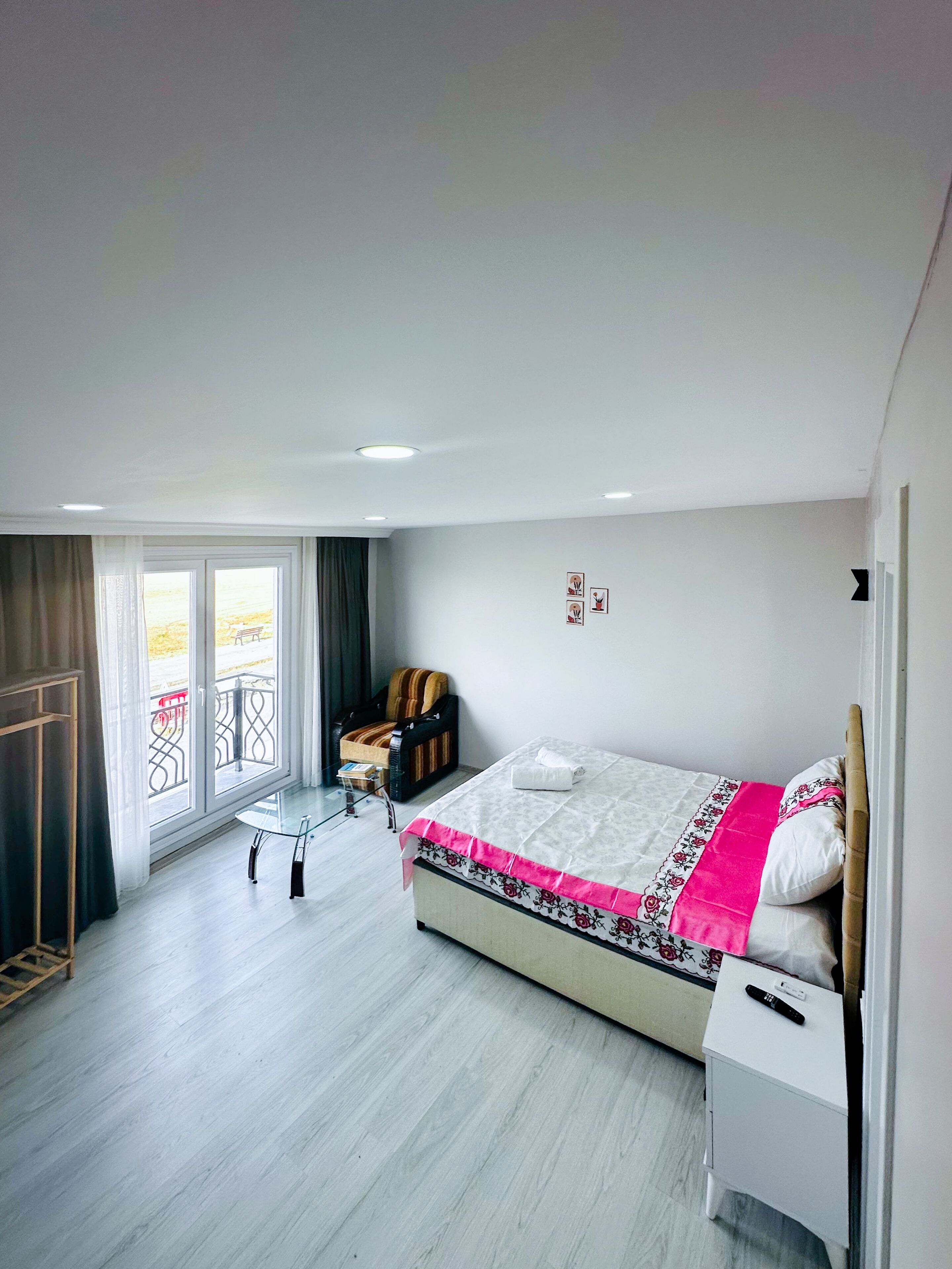 Une chambre à coucher avec un lit, une chaise, une petite table et une fenêtre donnant sur un paysage agréable.