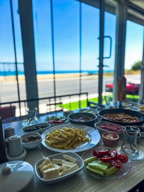 Una mesa con diversos alimentos, salsas y un jarro de vidrio.