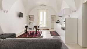 Un appartement moderne comprenant un coin repas, une cuisine et un salon.