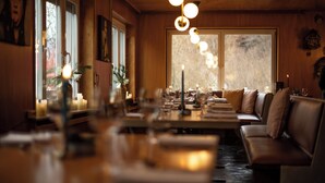 A cozy dining area with a long table, cushioned seating, and pendant lighting. - DAS SCHÖNE LEBEN Pop-Up Hotel (Hornberg)