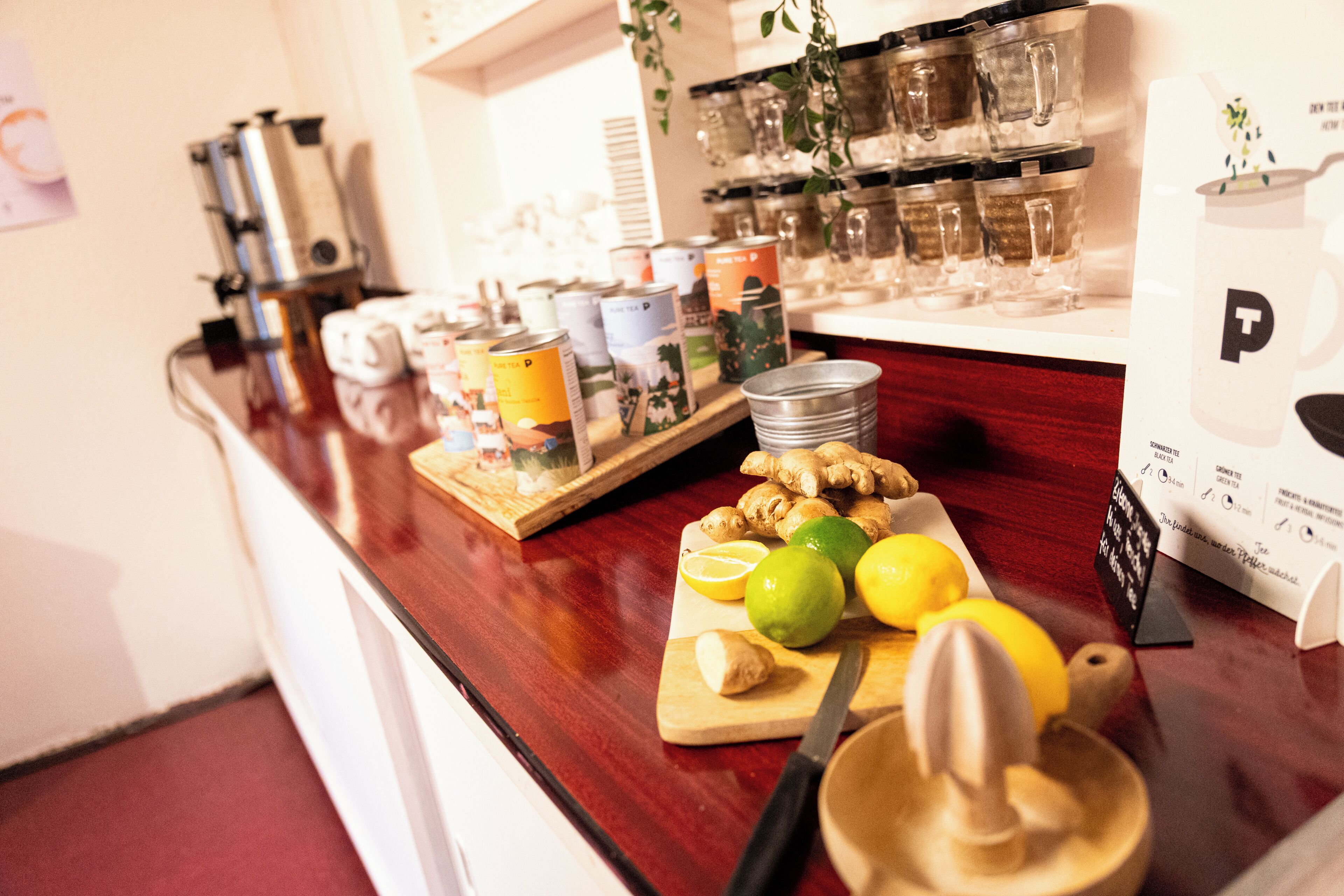 A kitchen counter with a cutting board, lemons, ginger, and a juicer.