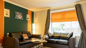 A living room with two leather sofas, a coffee table, and artwork on the walls. - Avenue House (Heald Green, Cheadle) (Heald Green)