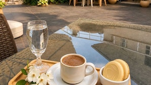 A patio with outdoor furniture, a glass table, and a beverage tray. - Amadeus Motel (Cinarcik)