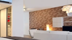 A modern bedroom with a bed, a wardrobe, and a kitchenette area. - Green Bliss Spacious Studio in Nu ez (Buenos Aires)