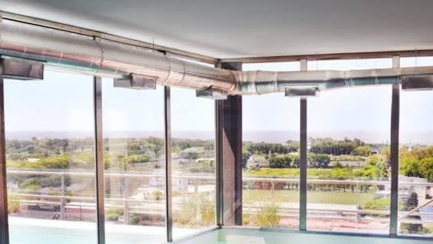 A modern indoor swimming pool with large windows offering a view of a landscaped area. - Green Bliss Spacious Studio in Nu ez (Buenos Aires)