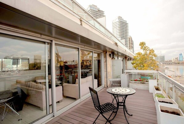 Enjoy a stylish outdoor space with a glass-enclosed balcony offering a city view, perfect for dining or socializing.