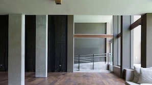 Ein großzügiger Innenraum mit Holzboden, großen Fenstern und modernem Design.
