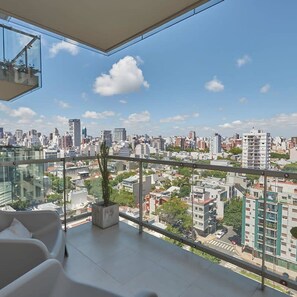 Un apartamento moderno con un balcón amplio y vistas a la ciudad.