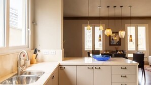 A modern kitchen with a central island, a built-in sink, and pendant lighting. - Tiete Classic I Stunning 3 Bedroom in Jardins (São Paulo)