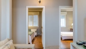 A hallway with a beige sofa, a leopard print pillow, and a wooden floor. - Tiete Classic I Stunning 3 Bedroom in Jardins (São Paulo)