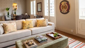 A living room with a sofa, coffee table, and decorative wall art. - Tiete Classic I Stunning 3 Bedroom in Jardins (São Paulo)