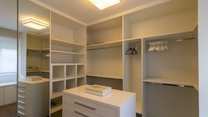 A modern walk-in closet with open shelving, a vanity with drawers, and hanging space. - Jardins Vintage I Chic 1-br Office in Jardins (São Paulo)