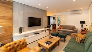 A modern living room with a flat-screen TV, a sofa, a coffee table, and a TV stand. - Jardins Vintage I Chic 1-br Office in Jardins (São Paulo)