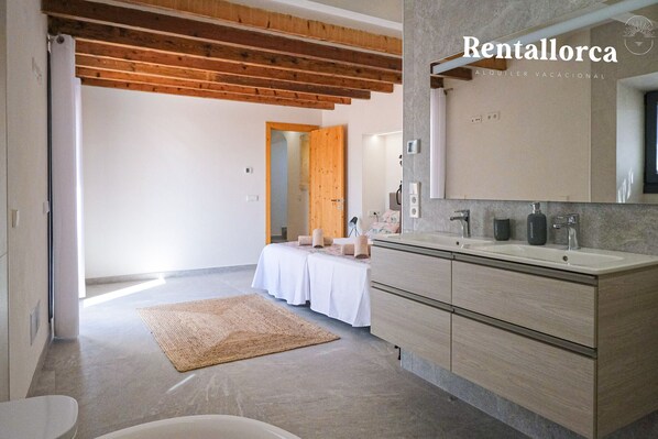 A modern bathroom with a large mirror, two sinks, and a wooden ceiling. - Ses Rotes by Rentallorca (Campanet)