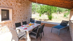A stone-walled outdoor dining area with a table set for breakfast, including croissants and orange juice. - Ses Rotes by Rentallorca (Campanet)