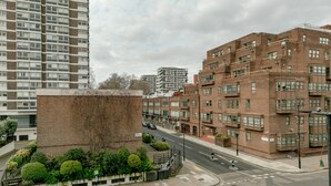Un edificio residencial de varios pisos con fachada de ladrillo, ventanas grandes y techo plano.