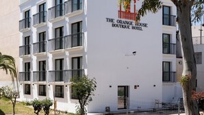 Un edificio moderno con balcones y un cartel que dice "The Orange House Boutique Hotel".
