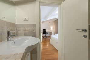 A modern bathroom with a large sink, a mirror, and a shower area. - Ammirato Duplex in Florence (Florence)