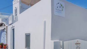 En vit byggnad med en skylt som visar att det är Villa Paradiso Santorini.