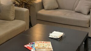 A modern living room with a sofa, a coffee table, a lamp, and a magazine. - Senda Hostel Retiro (Madrid)