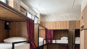 A dormitory room with bunk beds, wooden paneling, and a tiled floor. - Senda Hostel Retiro (Madrid)