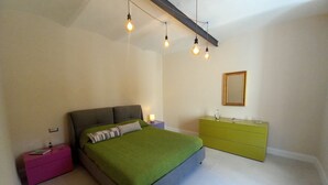 A bedroom with a bed, a dresser, a nightstand, and a mirror. - Lina romantic apartment Vallombrosa wifi nature (Toscana)
