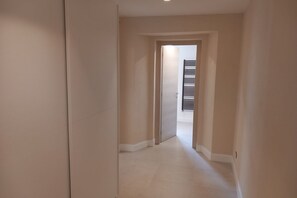 Um corredor com uma porta que dá para um quarto com radiador.