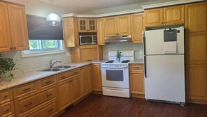 A kitchen with wooden cabinets, a white refrigerator, a stove, and a microwave. - Rest for your soul
Peace
Quiet
Nature
Secluded
Cozy


 (Lanark)