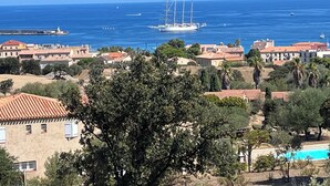 A coastal town with traditional Mediterranean architecture, a marina with sailboats, and a clear blue sea. - Appartement Climatisé vue Imprenable sur Mer. 2 ch. Salon Cuisine SB Terrasse (L'Île-Rousse)