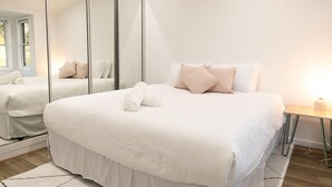 Ein Hotelzimmer mit einem großen Bett, einem Spiegel und einem Nachttisch.