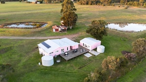 A large pink building with a covered patio and two cylindrical tanks.