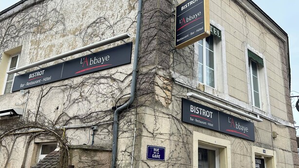 Un bâtiment portant les enseignes « BISTROT » et « L’ABBAYE », indiquant la présence d’un restaurant, d’un bar et d’un hôtel.