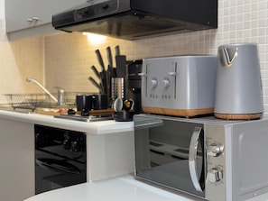 A kitchen with a built-in oven, a microwave, and a coffee maker.