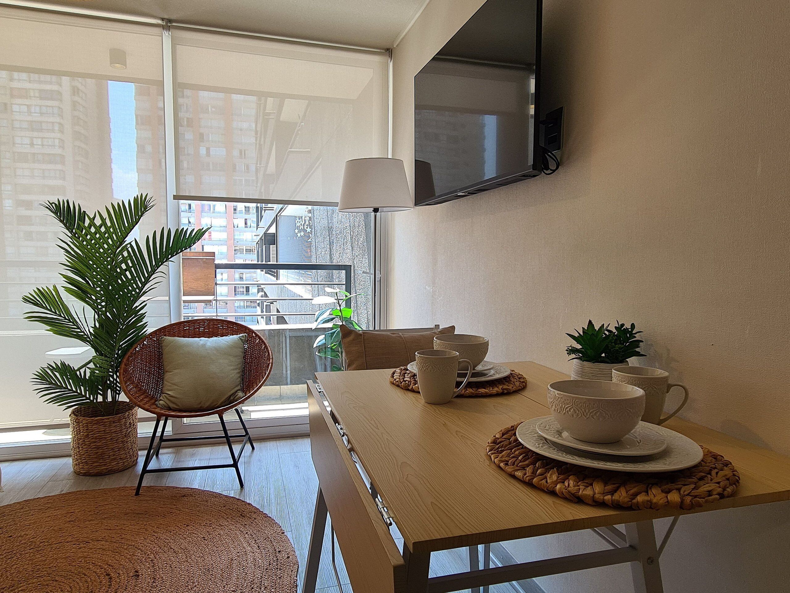 Un comedor moderno con una mesa de madera, individuales tejidos y una silla de mimbre.