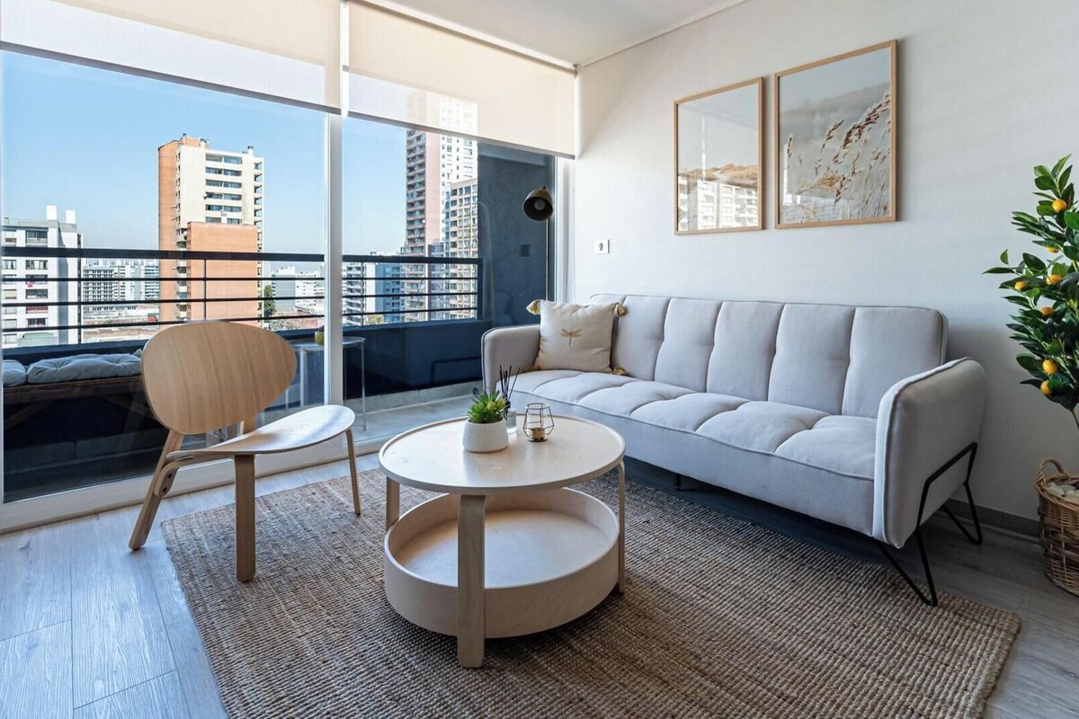 A modern living room with a sofa, a round coffee table, a chair, and a potted plant.