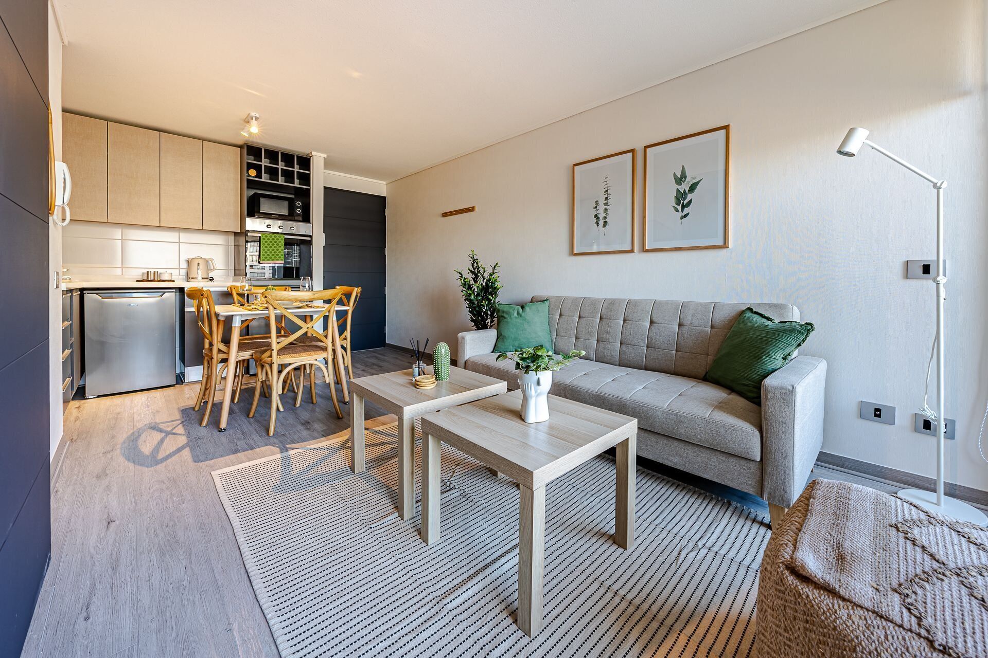 A modern living room with a sofa, coffee table, and dining area.