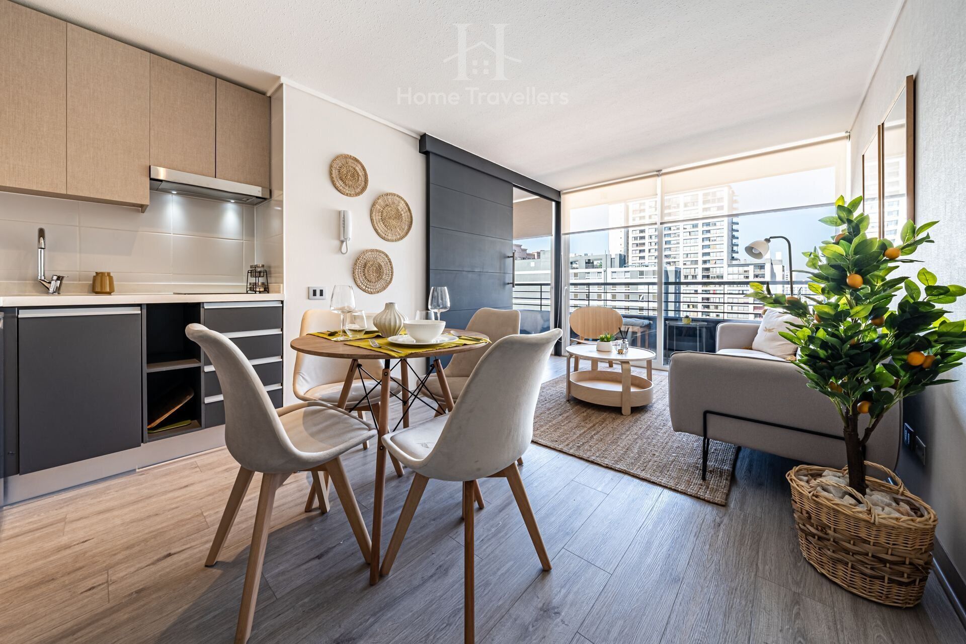 Una cocina moderna con comedor, un balcón con vistas a la ciudad y una sala de estar con sofá y planta.