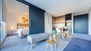 Un appartamento moderno con una camera da letto, zona soggiorno e cucina.